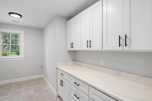 laundry area featuring cabinets and light tile patterned floors