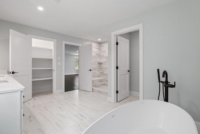 bathroom with a washtub and vanity