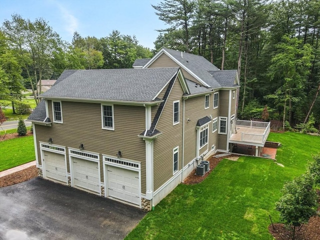 back of property with a yard, a garage, and cooling unit