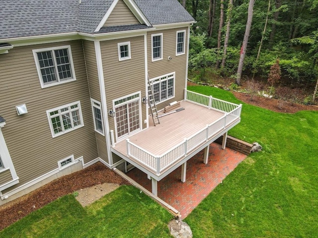 rear view of property featuring a wooden deck and a yard