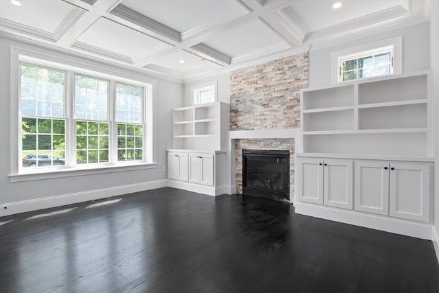 unfurnished living room with a stone fireplace, beamed ceiling, dark hardwood / wood-style floors, and coffered ceiling