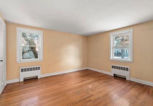 bonus room featuring wood-type flooring and radiator heating unit