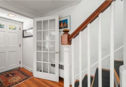 entryway featuring french doors, ornamental molding, and wood-type flooring