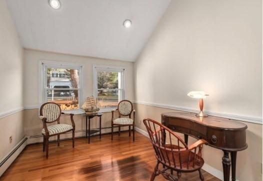 living area featuring baseboard heating, vaulted ceiling, and hardwood / wood-style floors