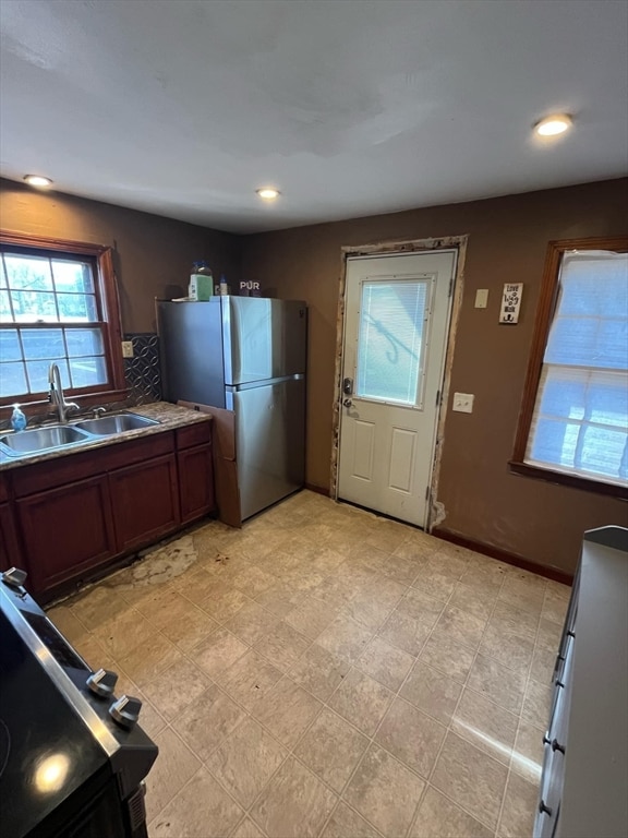 kitchen with stainless steel fridge, backsplash, range, and sink