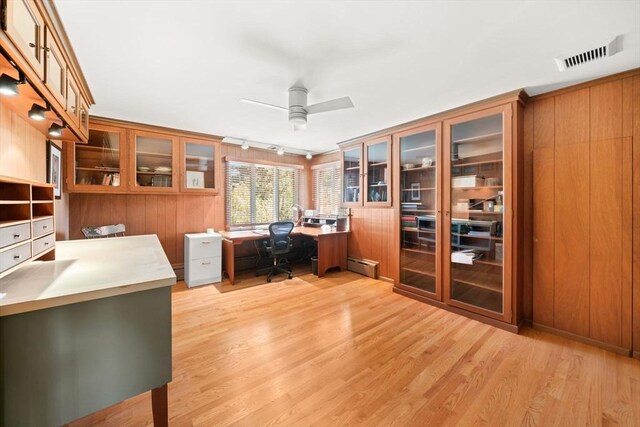 21 Fremont St, Dartmouth, MA 02748 - office area featuring built in study area, ceiling fan, a baseboard radiator, light wood-style flooring, and wood walls
