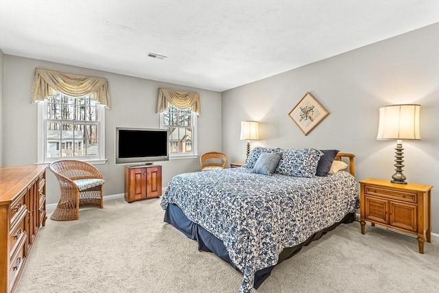 bedroom featuring visible vents, light carpet, and baseboards