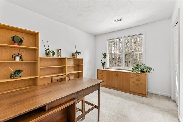 home office with light carpet, visible vents, and baseboards