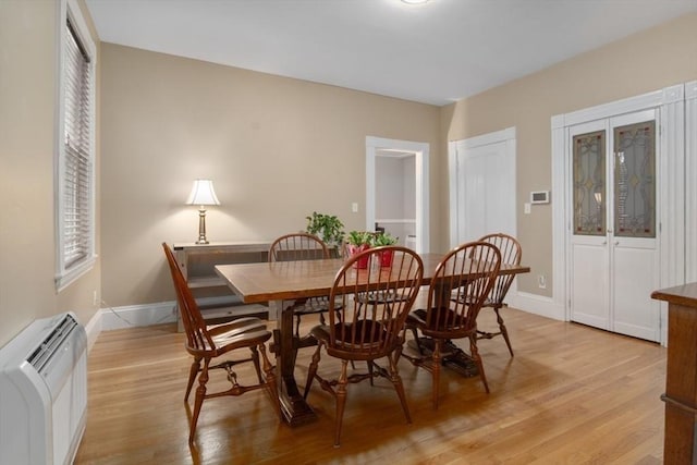 dining area with light wood-type flooring and baseboards