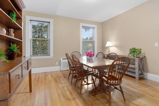 dining space featuring baseboards and light wood-style floors