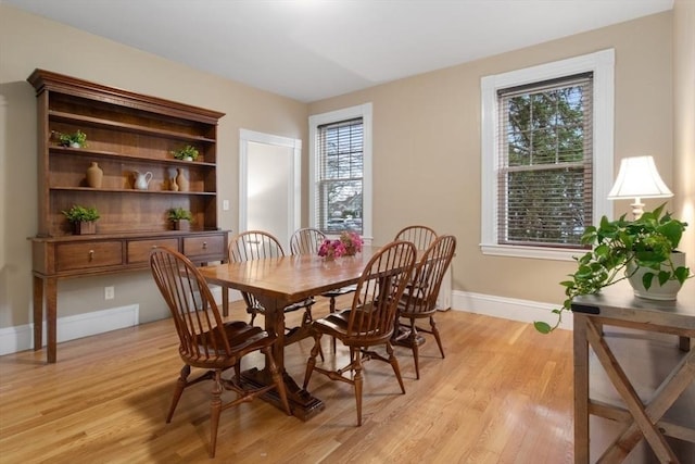 dining room with light wood-type flooring and baseboards