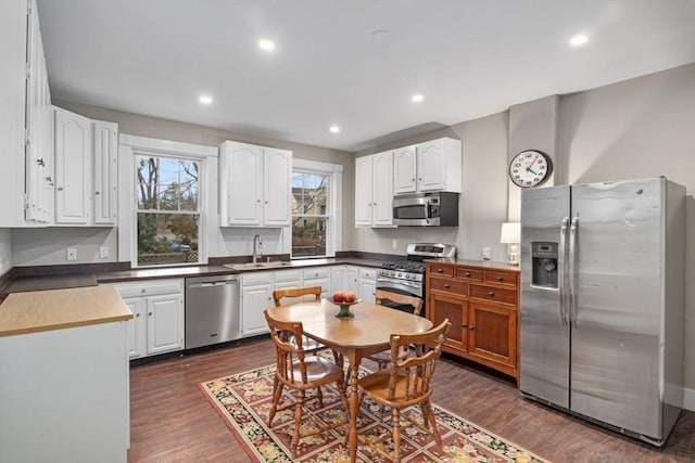 kitchen featuring dark wood-style floors, recessed lighting, a sink, appliances with stainless steel finishes, and white cabinetry