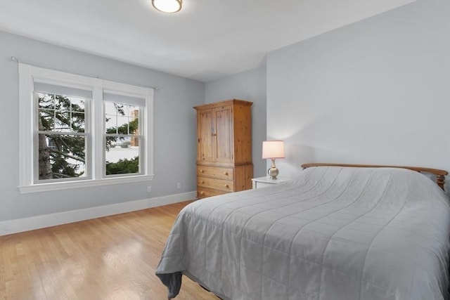 bedroom featuring light wood-style floors and baseboards