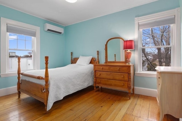 bedroom featuring baseboards, wood-type flooring, an AC wall unit, and ornamental molding