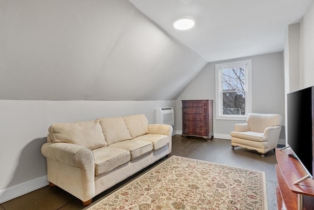 living area featuring heating unit, baseboards, and vaulted ceiling