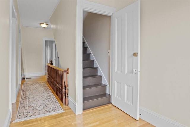 stairway featuring wood finished floors and baseboards