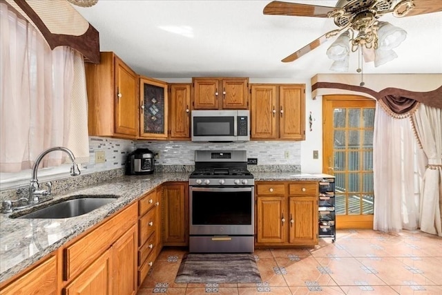 23 Vincent Cir, Worcester, MA 01604 - kitchen featuring appliances with stainless steel finishes, a sink, decorative backsplash, light tile patterned flooring, and light stone countertops
