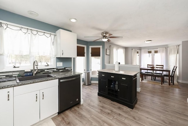 kitchen featuring sink, ceiling fan, white cabinetry, black dishwasher, and light hardwood / wood-style floors