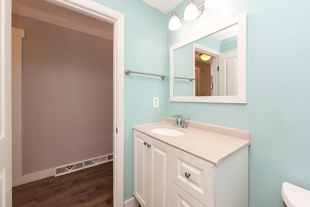 bathroom with vanity, hardwood / wood-style flooring, and toilet