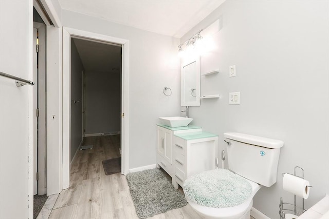 bathroom with wood-type flooring, toilet, and vanity