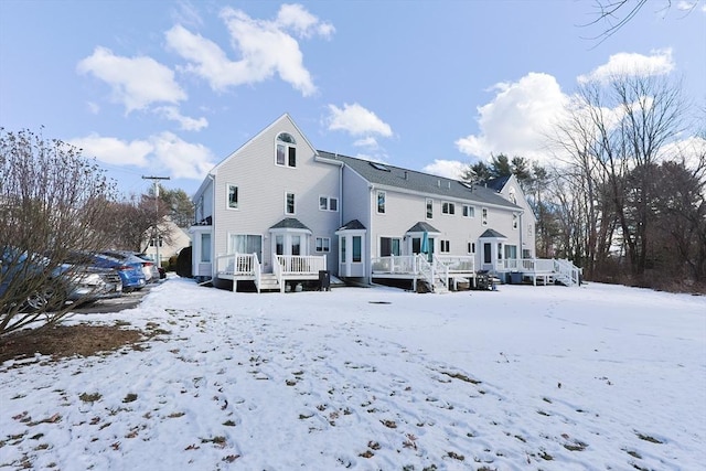 snow covered house featuring a deck