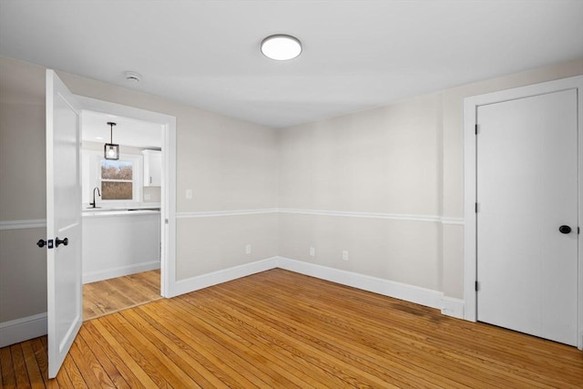 spare room with sink and hardwood / wood-style floors