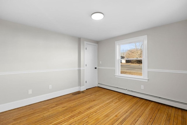 spare room with a baseboard radiator and light hardwood / wood-style floors