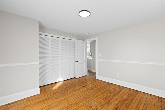 unfurnished bedroom featuring light hardwood / wood-style flooring and a closet