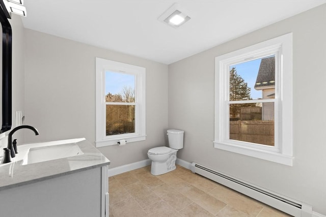 bathroom with vanity, plenty of natural light, a baseboard heating unit, and toilet