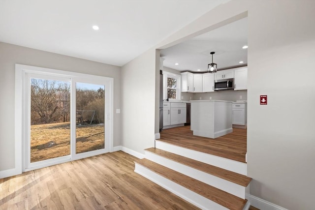 kitchen with pendant lighting, white cabinetry, a center island, and light wood-type flooring