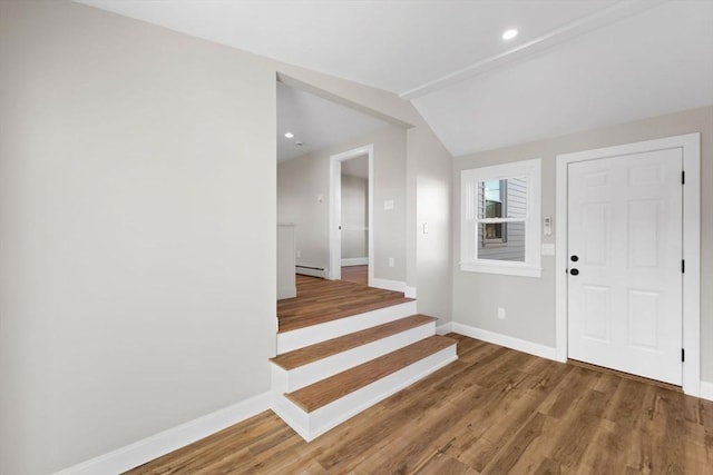 entrance foyer with lofted ceiling, a baseboard heating unit, and hardwood / wood-style floors