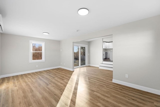 unfurnished living room with a wealth of natural light and light hardwood / wood-style floors