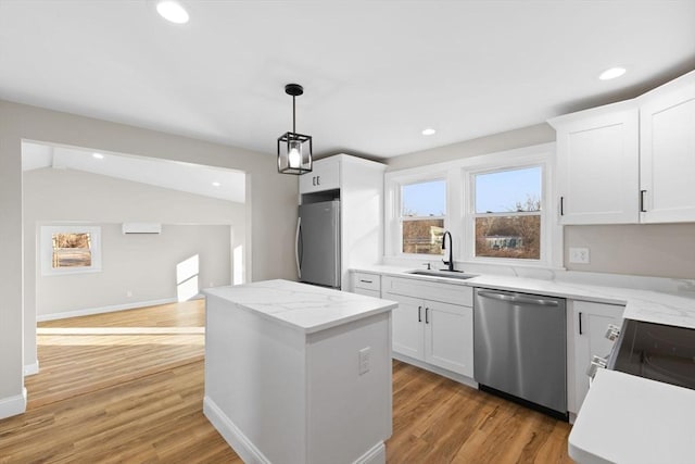 kitchen with pendant lighting, sink, stainless steel appliances, a center island, and white cabinets