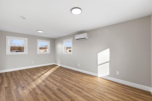 unfurnished room featuring hardwood / wood-style floors and a wall unit AC