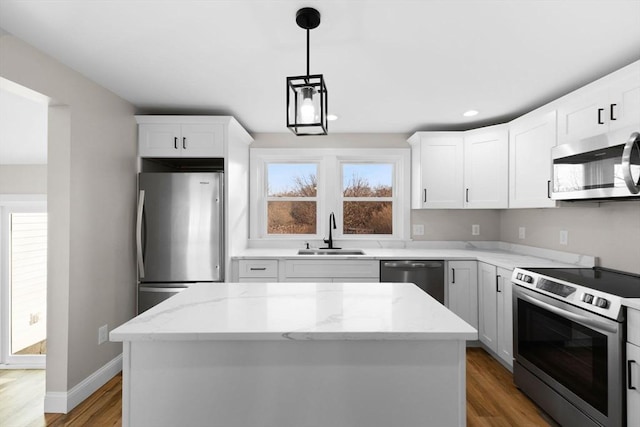 kitchen featuring pendant lighting, sink, a kitchen island, and appliances with stainless steel finishes