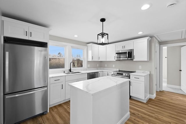 kitchen featuring white cabinetry, appliances with stainless steel finishes, sink, and a kitchen island