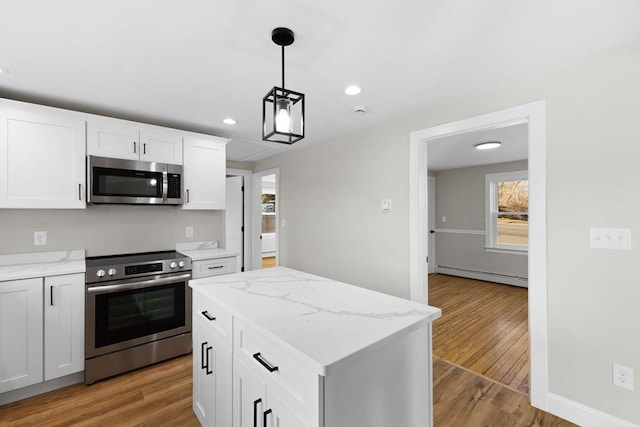 kitchen with white cabinetry, a center island, baseboard heating, appliances with stainless steel finishes, and pendant lighting