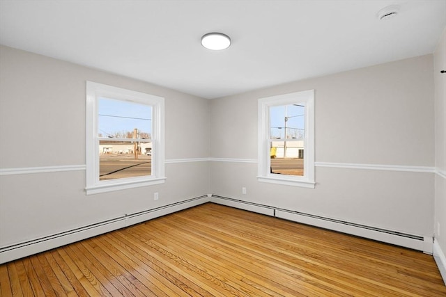 spare room with a baseboard radiator and light wood-type flooring