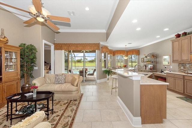 10852 Tiberio Dr, Fort Myers, FL 33913 - kitchen with ornamental molding, light countertops, a center island with sink, ceiling fan, and a sink