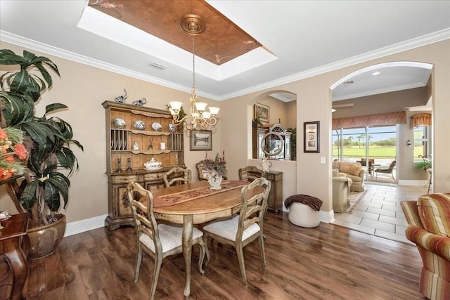 10852 Tiberio Dr, Fort Myers, FL 33913 - dining space with arched walkways, visible vents, an inviting chandelier, and wood finished floors