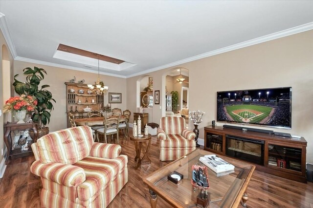 10852 Tiberio Dr, Fort Myers, FL 33913 - living room featuring arched walkways, ornamental molding, a chandelier, wood finished floors, and baseboards