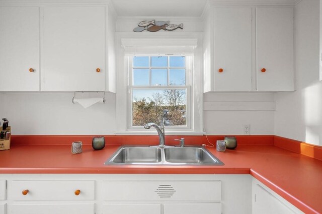 30 Captain Nickerson Ln, Dennis, MA 02660 - kitchen with white cabinets, ornamental molding, and a sink