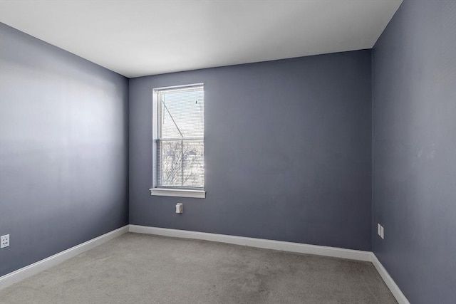 spare room with light carpet and baseboards