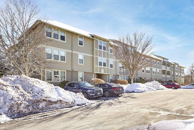 snow covered building featuring uncovered parking