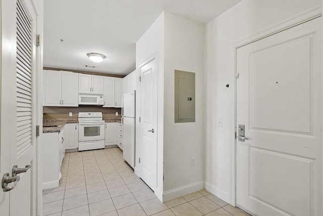 kitchen featuring light tile patterned flooring, white appliances, white cabinets, electric panel, and dark countertops