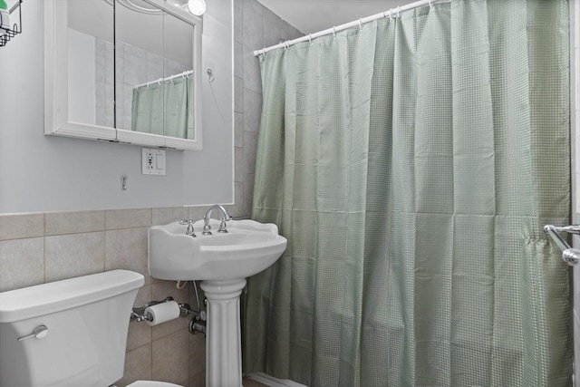 full bathroom with tile walls, toilet, and a shower with shower curtain