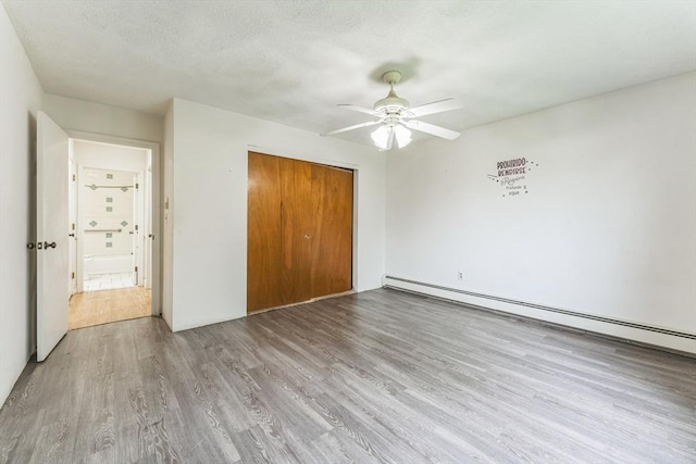 395 Merrimack St Unit 35, Methuen, MA 01844 - unfurnished bedroom with a baseboard radiator, wood finished floors, a closet, and a ceiling fan