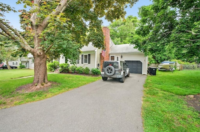 9 Arrowhead Ln, Dartmouth, MA 02748 - obstructed view of property with a front yard, an attached garage, driveway, and a chimney