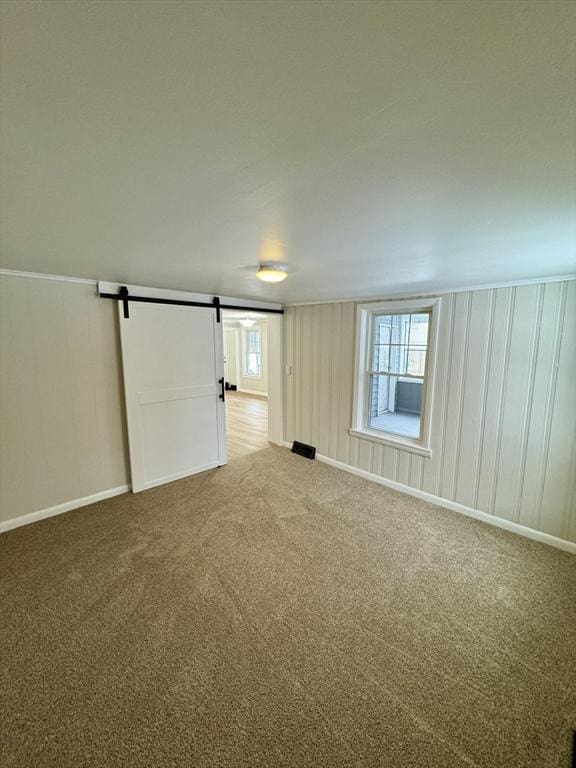 carpeted spare room with a barn door