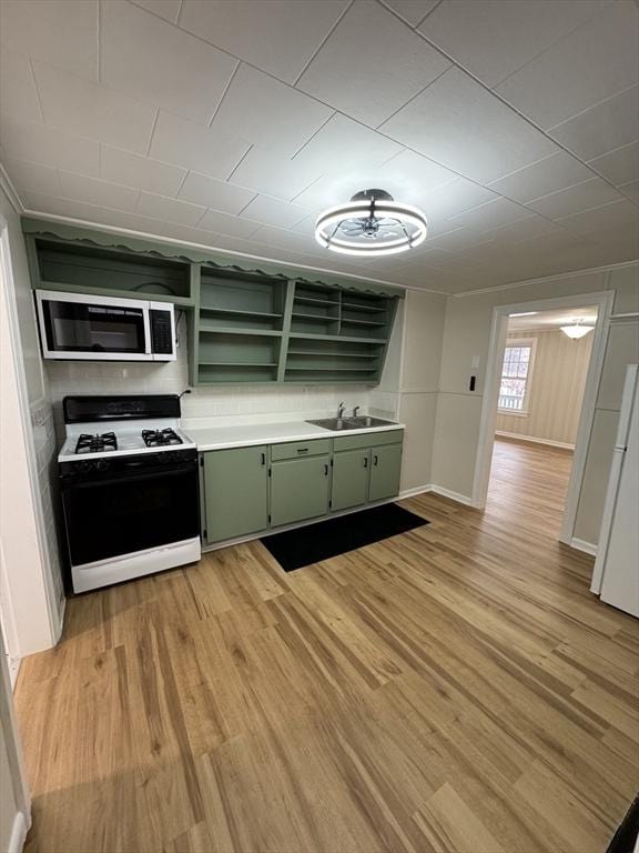 kitchen with sink, range with gas cooktop, green cabinetry, and light wood-type flooring